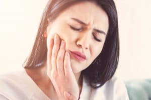 a lady suffering from severe tooth sensitivity